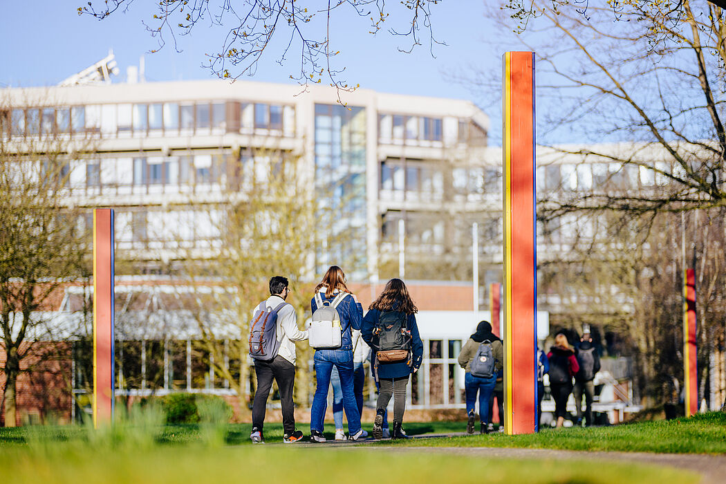 Group of people and colored stelae on the campus of Paderborn University.